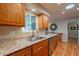 A well-lit kitchen area with stainless steel appliances, wood cabinets, and a sink beneath a window at 9402 N 109Th Dr, Sun City, AZ 85351