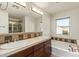 Bathroom featuring a dual sink vanity, soaking tub, and bright window at 958 S Henry Ln, Gilbert, AZ 85296