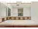 Tile-countered bathroom vanity featuring dual sinks, with view to shower at 958 S Henry Ln, Gilbert, AZ 85296