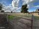 Fenced backyard space with a mature tree and partial view of the home's exterior and blue sky at 9620 S 156Th Pl, Gilbert, AZ 85234