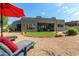 Exterior backyard view with covered patio, red umbrella, rock landscaping, and patio chairs at 9781 E Gamble Ln, Scottsdale, AZ 85262