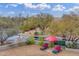 Aerial view of backyard showcasing the desert landscape and lounge area with a red umbrella at 9781 E Gamble Ln, Scottsdale, AZ 85262