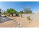 Desert landscaped backyard with gravel, trees, privacy wall, and accent rocks at 9781 E Gamble Ln, Scottsdale, AZ 85262