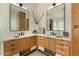 Bright bathroom featuring dual light wood vanities and framed mirrors with granite countertops at 9781 E Gamble Ln, Scottsdale, AZ 85262