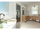 Bright bathroom featuring a soaking tub, leafy greenery and light wood dual vanities at 9781 E Gamble Ln, Scottsdale, AZ 85262