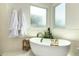 Bright bathroom featuring a soaking tub, leafy greenery and natural light from frosted windows at 9781 E Gamble Ln, Scottsdale, AZ 85262