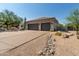 Exterior angle of home with desert landscaping and a long driveway leading to a two car garage at 9781 E Gamble Ln, Scottsdale, AZ 85262