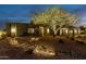 Beautiful home with desert landscaping and tree that is lit up at night with uplighting at 9781 E Gamble Ln, Scottsdale, AZ 85262