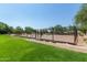 Fenced in tennis court with green field beyond at 9781 E Gamble Ln, Scottsdale, AZ 85262