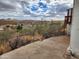 Expansive city views showcased from a balcony of this charming property, with distant mountains and cloudy blue skies at 981 N Sherwood Way, Queen Valley, AZ 85118