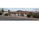 Desert home with white siding, security shutters and desert landscaping, set against the beautiful mountain backdrop at 981 N Sherwood Way, Queen Valley, AZ 85118