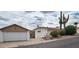 View of the exterior of a desert home with detached garage and mature landscaping at 981 N Sherwood Way, Queen Valley, AZ 85118