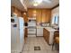 Functional kitchen with white appliances, wood cabinets and easy to clean tile floors at 981 N Sherwood Way, Queen Valley, AZ 85118