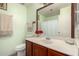 Bright bathroom featuring a vanity with a sink, a toilet, and a mirror at 10216 W Minnezona Ave, Phoenix, AZ 85037