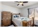 Cozy bedroom with natural light, a wood bed frame, decorative pillows and matching nightstand at 10216 W Minnezona Ave, Phoenix, AZ 85037