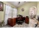 Office featuring a wooden desk and chair with natural light from the window at 10216 W Minnezona Ave, Phoenix, AZ 85037