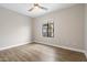 Bright bedroom with wood-look floors, neutral walls, ceiling fan, and a view from the large window at 10757 N 74Th St # 2003, Scottsdale, AZ 85260