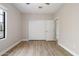 Neutral bedroom with wood-look floors, sliding closet doors, ceiling fan, and large window at 10757 N 74Th St # 2003, Scottsdale, AZ 85260