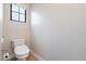 Simple and clean powder room features a white toilet, neutral walls, and a window at 10757 N 74Th St # 2003, Scottsdale, AZ 85260