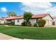 Manicured lawn, red tile roof, arched windows, and mature tree on a sunny day at 109 W Kathleen Rd, Phoenix, AZ 85023