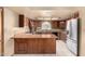 Well-lit kitchen with stainless steel appliances, wood cabinetry, a center island and tiled flooring at 109 W Kathleen Rd, Phoenix, AZ 85023