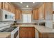 Well-lit kitchen features wooden cabinets, countertops, white appliances, and a sink with a window view at 111 S Greenfield Rd # 660, Mesa, AZ 85206