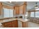 Kitchen with light wood cabinets and laminate countertops opens to the living room with a floral sofa at 111 S Greenfield Rd # 660, Mesa, AZ 85206