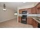 Spacious kitchen featuring tile floors, dark cabinetry, granite countertops, and updated appliances at 11388 N 114Th Dr, Youngtown, AZ 85363