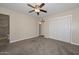 Bright main bedroom with carpet flooring, a ceiling fan, and a closet for ample storage at 11388 N 114Th Dr, Youngtown, AZ 85363