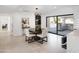 Elegant dining room with a modern table set, stylish light fixture, and access to the outdoor kitchen at 11601 N 64Th Pl, Scottsdale, AZ 85254