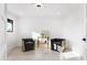 Bright sitting room features stylish chairs, modern lighting, and a decorative gold bar cart at 11601 N 64Th Pl, Scottsdale, AZ 85254