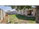 Manicured backyard featuring a lush green lawn and covered patio, great for entertaining at 12360 W Sherman St, Avondale, AZ 85323