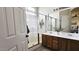 Bathroom featuring double sinks, wooden cabinets, and glass enclosed walk-in shower at 12360 W Sherman St, Avondale, AZ 85323