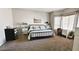 Bright bedroom with a modern iron bed frame, light gray walls, desk and lots of natural light at 12360 W Sherman St, Avondale, AZ 85323