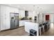 Well-lit kitchen with stainless steel appliances, white cabinets, a center island with bar seating at 12806 W Jadestone Dr, Sun City West, AZ 85375