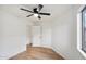 Bright bedroom featuring ceiling fan, wood floors and a view through the open door at 13326 W Watson Ln, Surprise, AZ 85379