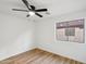 The bedroom features wood-look flooring, natural light from the window and a ceiling fan at 13326 W Watson Ln, Surprise, AZ 85379