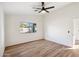 Bedroom featuring wood floors, a window with a view to the back, and a ceiling fan at 13326 W Watson Ln, Surprise, AZ 85379