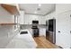 Bright kitchen with white cabinetry, modern appliances, marble counters, and light wood flooring at 13326 W Watson Ln, Surprise, AZ 85379