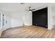 Bright living room with modern accent wall, ceiling fan, and light wood-style flooring at 13326 W Watson Ln, Surprise, AZ 85379