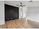 Bright living room with a modern accent wall, ceiling fan, and light wood-style flooring at 13326 W Watson Ln, Surprise, AZ 85379