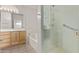 Bright bathroom with wooden cabinets, double sinks, a large mirror, tub, and glass shower at 1349 E Anasazi St, Mesa, AZ 85203