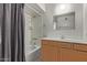 Standard bathroom featuring a shower-tub combo, wood cabinets, and tiled floors at 1349 E Anasazi St, Mesa, AZ 85203