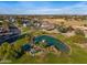 Scenic aerial view of a community featuring a pond with a waterfall, lush landscaping, and a glimpse of surrounding homes at 1349 E Anasazi St, Mesa, AZ 85203