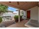 Inviting front entry with wood door, a covered porch and green shrubbery at 1349 E Anasazi St, Mesa, AZ 85203