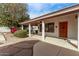 Charming covered front porch featuring a wood door and lush landscaping at 1349 E Anasazi St, Mesa, AZ 85203