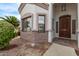 The exterior of the home featuring a covered entrance, textured stone accents, and verdant landscaping at 1349 E Anasazi St, Mesa, AZ 85203