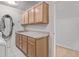 Bright laundry room features overhead storage, a sink, and access to another room at 1349 E Anasazi St, Mesa, AZ 85203