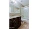 This bathroom has a shower and tub combination and a dark wood vanity with a granite sink at 14005 N 19Th Way, Phoenix, AZ 85022