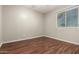 A neutral bedroom featuring laminated floors and ample natural light from the window at 14408 N 35Th Ave, Phoenix, AZ 85053